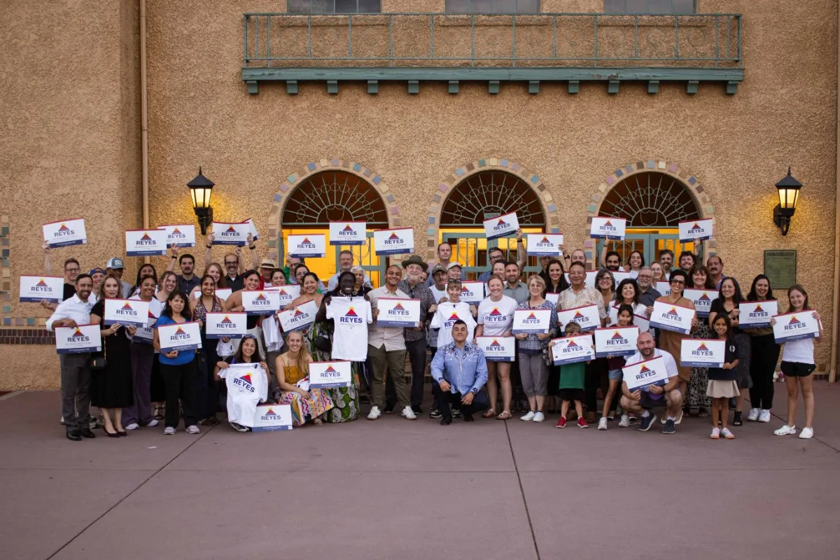 Dozens of neighbors holding Reyes signs at the City Park pavilion